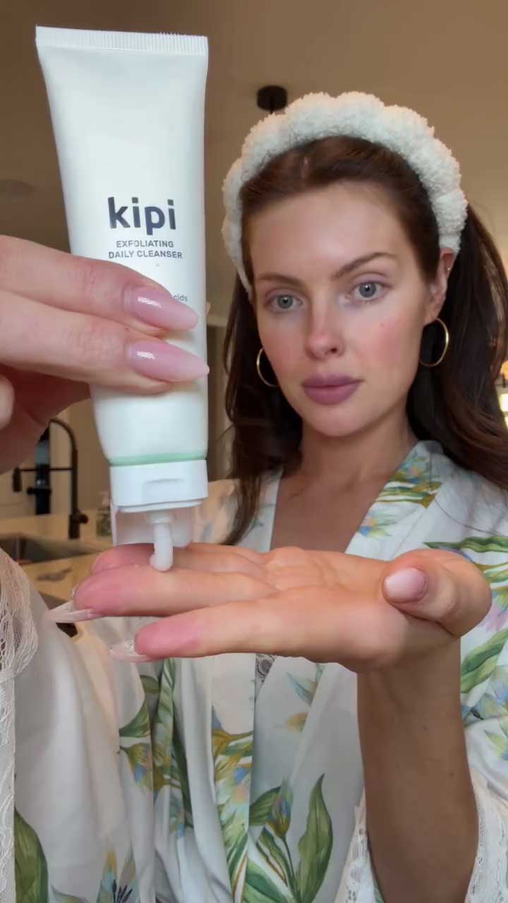 Woman holding a tube of Kipi cleanser with a close-up of the product.