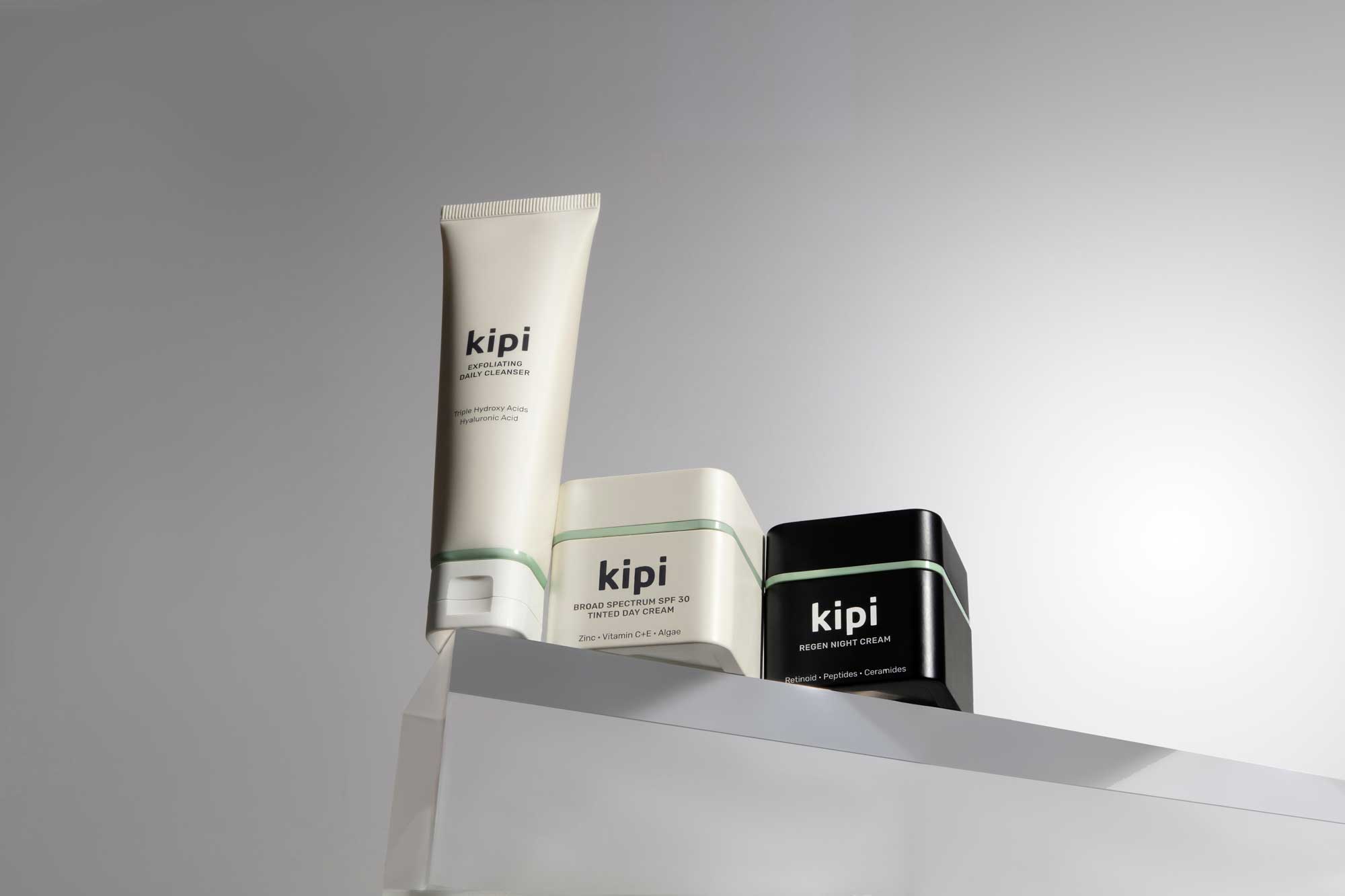 Three skincare products labeled 'Kipi' on a gray background